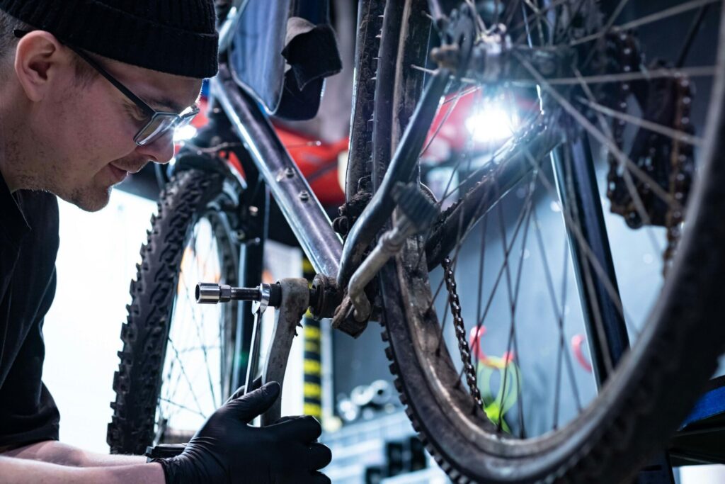 Hombre haciendo mantenimiento de bicicletas con trípode